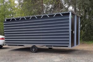 Fahrbare Weidehütte Varimobil DLV (7 × 6 m, mit 2 Vordächern) für Pferde – beim Transport am Anhänger